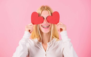 Kız neşeli aşık. Kız kalp sembol sevgi ve romantik pembe arka plan tutun. Aşkın gözü kördür. Sevgililer günü geleneksel olarak daha önemli kadınlar için görülmüştür. Kadın aşk kutlamak