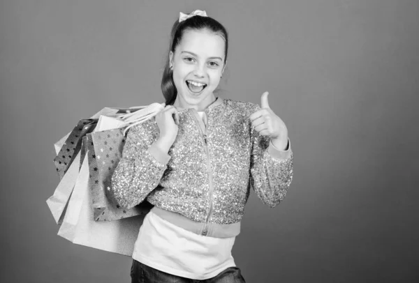 Metà prezzo. Alla moda infantile. commessa con pacco. Saldi e sconti. Un bambino felice. Ragazzina con dei regali. Ragazzina con borse della spesa. offerta speciale. Risparmio acquisto vacanze. vendita a metà prezzo — Foto Stock