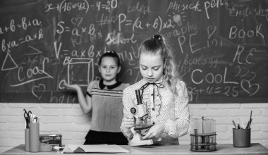 Küçük bilim adamları mikroskopla çalışır. Okul laboratuarındaki küçük kızlar. Mikroskop. Kanını test ediyorum. Mikroskop kullanan çocuklar. Biyoloji dersi. Okula geri dön. laboratuvarda bilim deneyleri