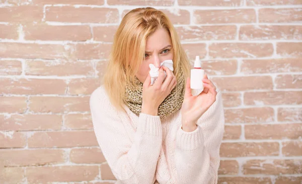 Bunged up nose. Cute woman nursing nasal cold or allergy. Pretty girl with runny nose holding nasal drops. Suffering from asthma or allergic rhinitis. Sick woman injecting drops into nose — Stock Photo, Image