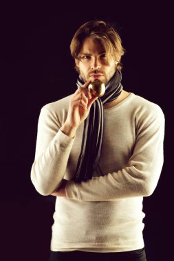 Çizgili eşarplı sakallı adam altın elmayı tutuyor.