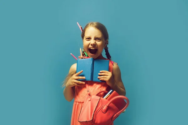 Dívka s růžový vak drží otevřené modré notebook — Stock fotografie