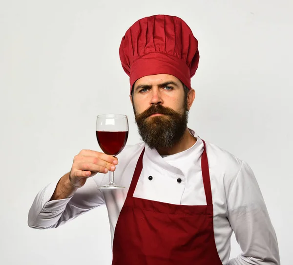 Kocken håller i ett glas rött vin. Laga mat med allvarligt ansikte — Stockfoto