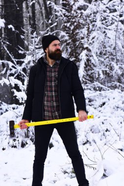 Düşünceli yüzlü, ormanı karla kaplı bir adam..