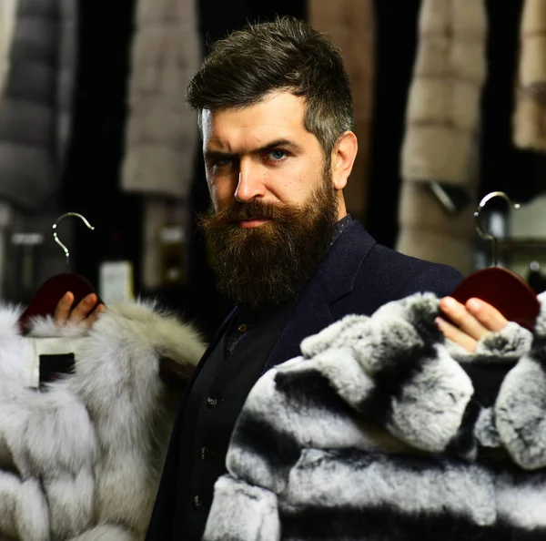 El tipo con barba elige abrigos peludos. Rico concepto de moda . —  Fotos de Stock