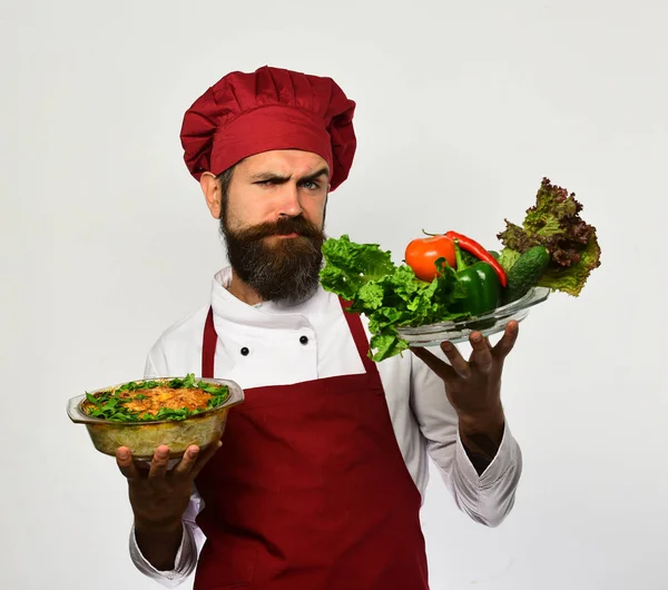 Man med skägg, vit bakgrund. Chef håller potatis och grönsaker — Stockfoto