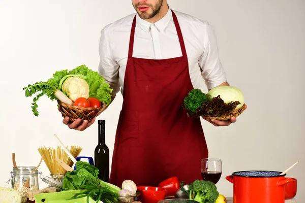 Cocinero trabaja en cocina cerca de la mesa con verduras y herramientas — Foto de Stock