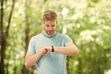 Akıllı fitness. Fit atlet spor izlemek ile onun fitness aktivitesi izleme. Yakışıklı atlet açık eğitim sırasında fitness izci kullanarak. En iyi fitness cihazı ile sağlığını izleme