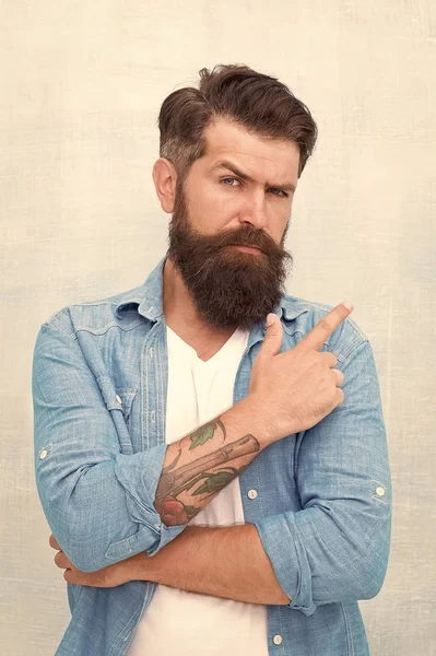 Salon de coiffure. Macho bien entretenu. Brutal bel homme hipster sur fond de mur gris. Homme barbu style branché hipster. Hipster avec barbe et moustache porte une chemise en denim. Concept de beauté masculine — Photo