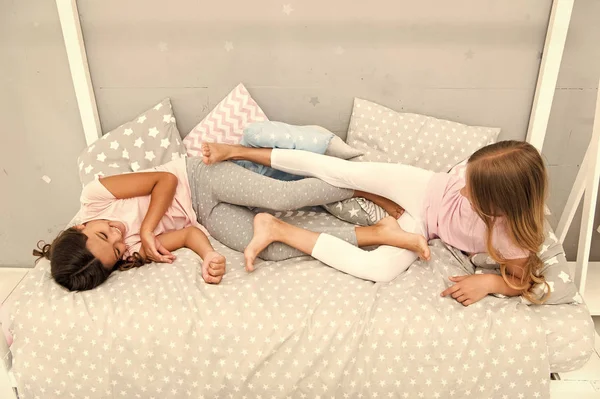 Having fun together. fun before sleep. best friends. sisters playing in bed. sweet dreams. pajama party in bedroom. childhood happiness. kids friendship. happy small girls. good morning — Stock Photo, Image