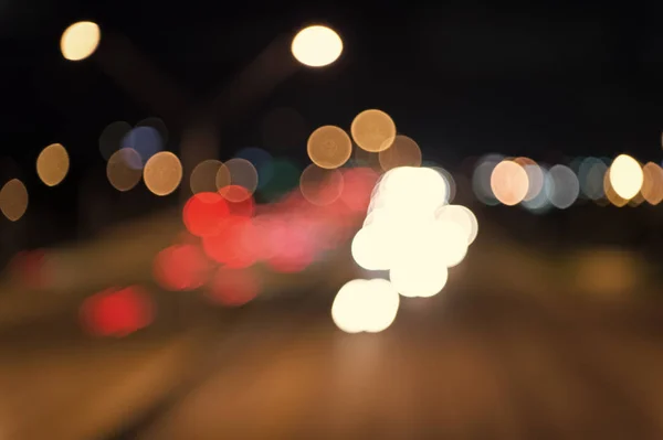 Tráfego urbano. Luzes de carro desfocadas noite. Noite urbana. Luzes desfocadas fundo. Luzes nocturnas. Iluminação e iluminação. Lâmpadas brancas e vermelhas turvas. Observando o transporte se movendo na rua — Fotografia de Stock