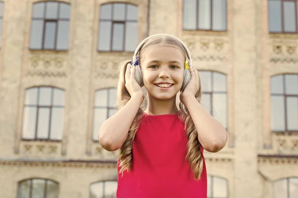 Věnuje se krásné hudbě. Šťastné dítě poslouchá venku hudbu. Roztomilé malé dítě si vychutnat hudbu hrát ve sluchátkách. Její oblíbená hudba. Volný čas a potěšení. Zábava. Relax — Stock fotografie