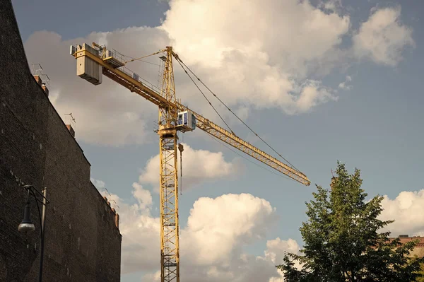 Plaats in aanbouw. Bouwkraan op bewolkte lucht. Kraanvogel voor de bouw. Gebouw aan het bouwen. Structuur toevoegen aan onroerend goed. Residentiële of niet-residentiële bouw — Stockfoto