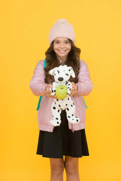 A amiga favorita dela. Criança feliz segurar brinquedo e maçã. Menina sorrir com brinquedo macio e frutas. Um lanche da escola. Brinquedo para jogar. Loja ou loja de brinquedos para crianças. Aprenda e jogue. Escola e educação — Fotografia de Stock