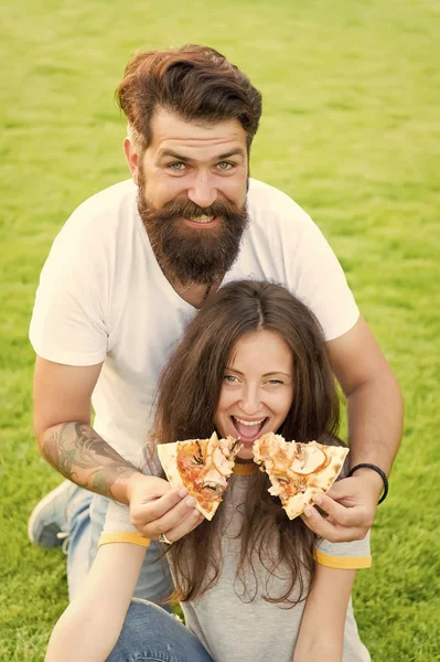 É engraçado. piquenique de verão na grama verde. Dieta. casal feliz comendo pizza. Comida saudável. casal apaixonado namoro. fome. fim de semana familiar. fast food. homem barbudo hipster e mulher bonita comer pizza — Fotografia de Stock