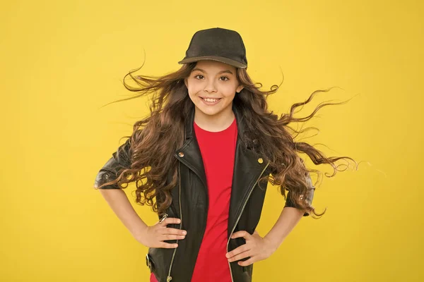 女の子愛らしい子供長い波状の髪黄色の背景。風はまた、髪を損傷することができます。強い持続的な風は、波状と巻き毛の長い髪にもつれやスナッグを作成することができます。風のダメージから髪を守る — ストック写真