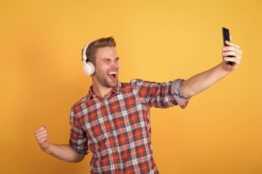 Canlı konser çevrimiçi. Dinlemeyi hak eden en iyi müzik uygulamaları. Guy kullanıcı mobil uygulaması. Müzik aboneliği al. Adam memnun müzik dinliyor modern kulaklıklar ve akıllı telefon. Taze müzik konsepti