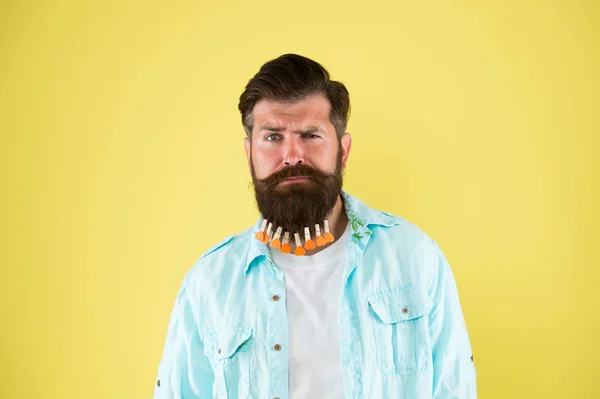 Hip und stylisch. Brutaler Hipster mit Wäscheklammern-Herzen. bärtiger Mann lässigen Stil gelb Hintergrund. Valentinstag. Haartrocknen im Friseur. individuelle Frisur für Männer. Mann Wäscheklammer am Bart — Stockfoto