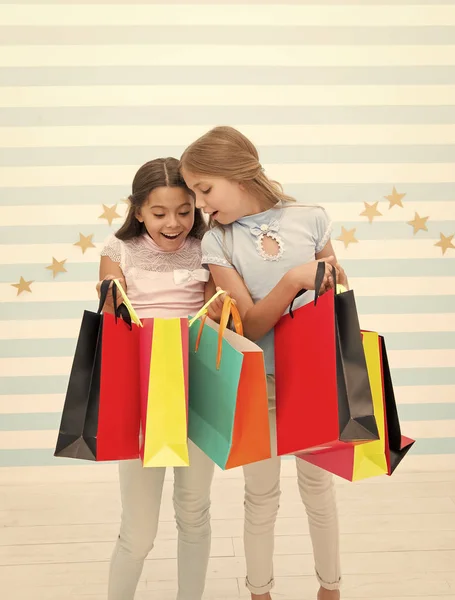 Shopping, der Ort zum Spaß. Niedliche kleine Käufer. entzückende Mädchen, die in Einkaufstüten schauen. Kleine Kinder kaufen gerne ein. Einkaufen im echten Leben — Stockfoto