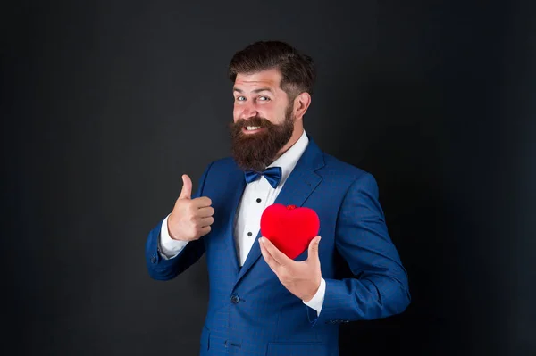 Estás com bom aspecto. Celebração de férias. conceito de amor. Dia Mundial do Coração. Um hipster barbudo brutal num fato formal. Homem de negócios de gravata borboleta. Saúde. Decoração do dia dos namorados. smoking homem com coração vermelho — Fotografia de Stock