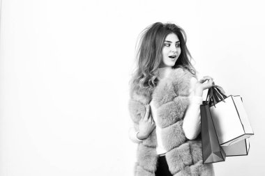 Fashionista Cuma siyah giysiler satın almak. Beyaz arka plan alışveriş kız makyaj tüylü mor yelek. Alışveriş ve hediyeler. Kadın alışveriş lüks butik. Bayan alışveriş torbaları kalın. Siyah Cuma indirim