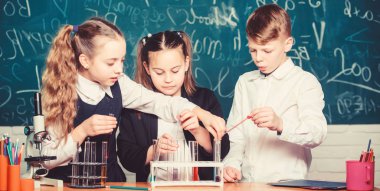 Laboratuvarda mikroskopla biyoloji deneyleri yapan öğrenciler. Biyoloji eğitimi. Biyoloji ekipmanları. Küçük çocuklar laboratuvarda kimya öğreniyor. Mutlu çocuklar. Biyoloji dersi. Genç ve kendinden emin bilim adamı