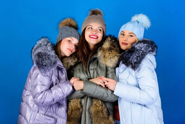 Emotional women in jackets. Group friends hang out together. Female clothes shop. Modern trendy female outfit. Gorgeous girls makeup faces cuddling. Female fashion. Girls friends having fun in winter