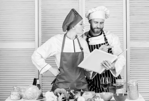 Woman chef and man cooking food together. Culinary family concept. Couple in love cooking healthy recipe. Amateur cook read book recipes. Improve cooking skill. Book recipes. Helpful culinary book