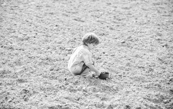 Tag der Erde. Neues Leben. Sommerhof. ökologisches Leben. Öko-Bauernhof. Mensch und Natur. Glücklicher Kindergärtner. Botaniker. Frühlingszeit. Kleines Kind beim Pflanzen einer Blume. natürliche Böden. neue Technologien in der Landwirtschaft — Stockfoto