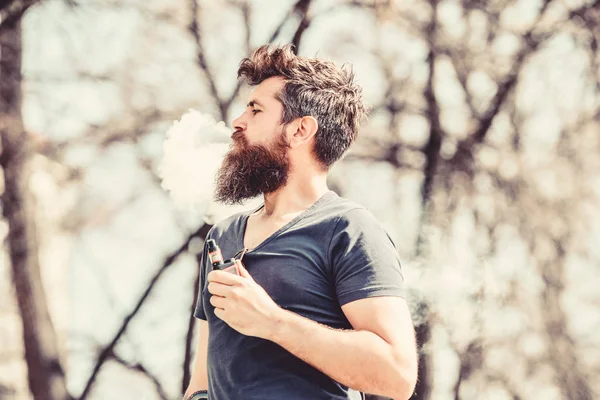 Hipster maduro con barba. hipster hombre mantenga el dispositivo de vapeo. Seguridad y adicción a la salud. inhalando vapor. Fumar cigarrillos electrónicos. Un brutal macho barbudo fumando cigarrillo electrónico. Retrato de la masculinidad —  Fotos de Stock