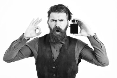 Sakallı adam, elinde parfüm tutuyordu.