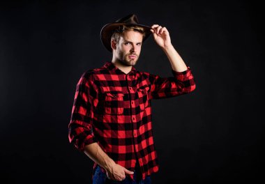 Amerikan geleneği. Klasik tarz adam. Vahşi Batı eski kovboy. Kırsal kesimdeki kovboy. Batı. Batı kovboy portresi. Vahşi batı rodeosu. Şapkalı yakışıklı adam. Çiftlikte kareli gömlek