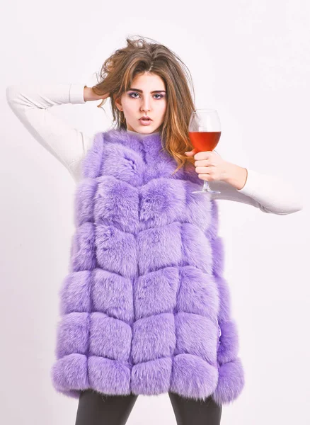 Woman enjoy wine. Lady curly hairstyle likes expensive luxury wine. Hedonism concept. Reasons drink red wine in wintertime. Girl fashion makeup wear fur coat hold wine glass. Alcohol and cold weather