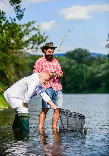 Hombre barbudo y brutal pesca hipster. Día de la familia. Equipo de pesca. Paz mental y tranquilidad. Peces de agua dulce. Día activo. Amigos pescando peces. Hobby y recreación. Captura de peces con alma gemela —  Fotos de Stock