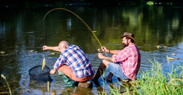 Black market caviar. Poachers fishing. Trap for fish. Men sit at riverside with fishing equipment. Illegal hunting caviar. Extracts eggs from sturgeon caught river. Poaching crime and fishing license — Stock Photo, Image