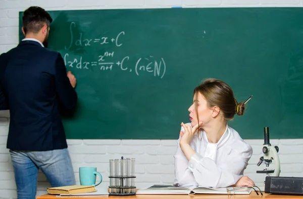 Professor e aluno perto do quadro. Formação universitária. No liceu. A resolver tarefa. Homem escrevendo em fórmulas de matemática quadro-negro. A dar aulas na universidade. Educação universitária. Transferência de conhecimento — Fotografia de Stock