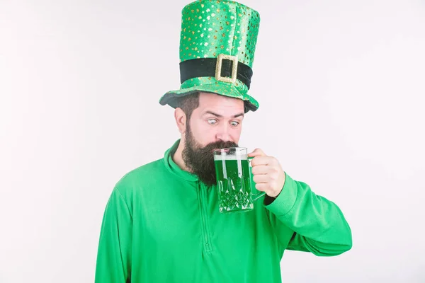 Man skäggiga hipster rolig hatt dricka pint öl. Skål koncept. Färgad grön öl. Grön öl del av firandet. Irländsk pub. Alkohol konsumtion integral del Saint Patricks dag. Irländsk kultur — Stockfoto