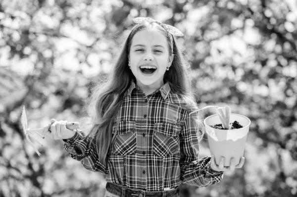 Tuinieren is een vredige meditatieve bezigheid. Tuinieren lessen. Tuinonderhoud. Ecologisch onderwijs. Meisje dat planten plant. Plantseizoen. Kind schattig kind houden bloempot en schoffel tuinieren gereedschap — Stockfoto