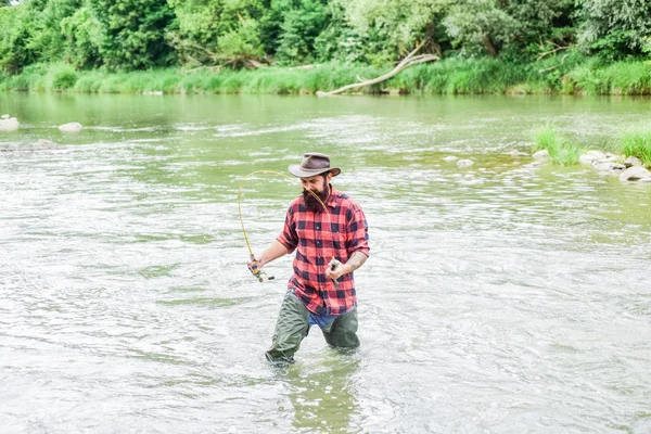 Pasatiempo masculino Fisher. Pescado en gancho. Hombre brutal parado en el agua del río. Hombre barbudo pescador. La pesca requiere ser consciente y estar plenamente presente en el momento. Equipo de pesca Fisher. Descanso y recreación — Foto de Stock