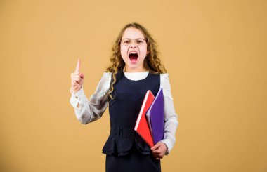 Stresli küçük kız öğretmen olmak istiyor. Günlük notları için not defteri. Ders çalışmak. Bilgi ve eğitim. Okula dönelim. Ev ödevi. Kağıt klasörlü küçük bir kız. İnanılır gibi değil. Hayır.