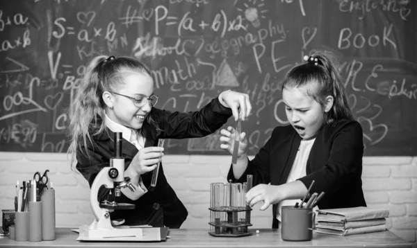 Mikroskop und Reagenzgläser auf dem Tisch. pädagogisches Experimentierkonzept. Vorsicht bei der Durchführung chemischer Reaktionen. Grundkenntnisse in Chemie. Mädchen studieren Chemie. Chemie-Studium interessant machen — Stockfoto