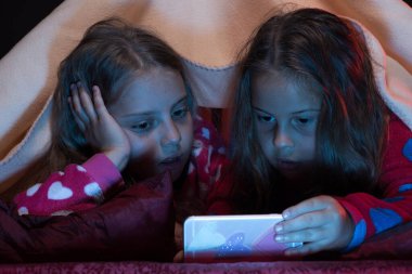 Siyah arka planda kırmızı pijama giyen çocuklar.