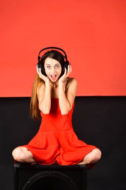 Kırmızı ve siyah arka plan üzerinde siyah hoparlör DJ oturur.