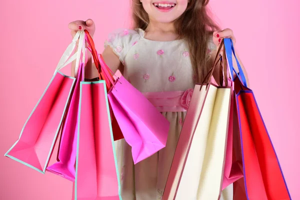 Lady shopper en vestido, cabello ondulado. Chica sostiene bolsas de compras —  Fotos de Stock