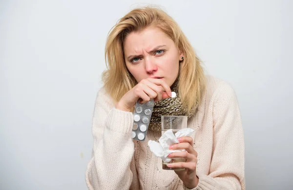 Pastillas para hacerla saludable. Mujer enferma que trata los síntomas causados por el resfriado o la gripe. Medicamentos y aumento de la ingesta de líquidos. Mujer malsana sosteniendo pastillas y vaso de agua. Enfermo chica tomando anti frío píldora —  Fotos de Stock