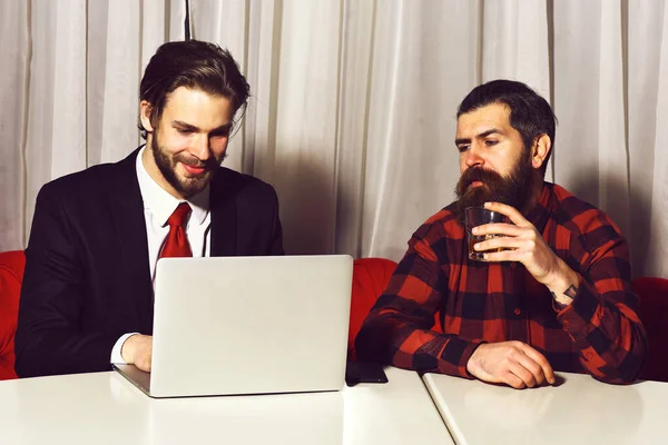 Γενειοφόροι άνδρες, επιχειρηματίες με ένα ποτήρι ουίσκι, φορητό υπολογιστή και τηλέφωνο — Φωτογραφία Αρχείου