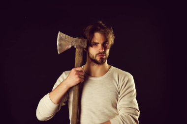 Sıradan saç stili olan sakallı, vahşi adam elinde keskin bir balta tutuyor.