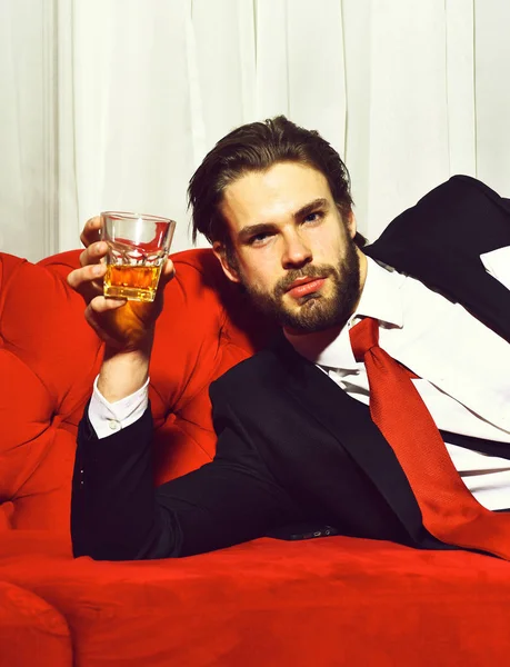 Uomo barbuto, uomo d'affari in possesso di un bicchiere di whisky in cravatta rossa — Foto Stock