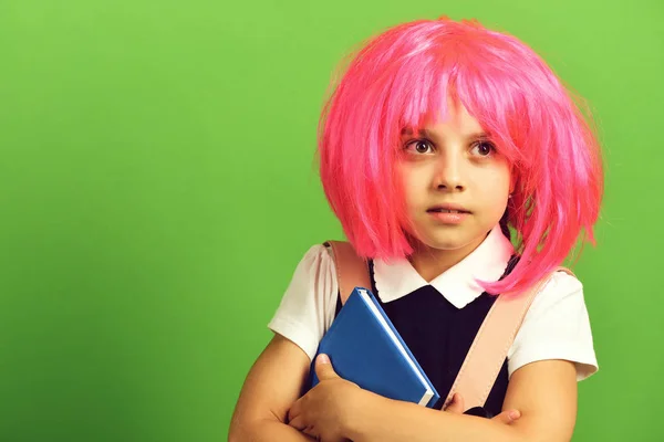 School girl in wig with surprised face on green background — Stock Photo, Image