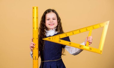 Eğitim ve okul konsepti. Zekice ve zekice bir fikir. Boyut ve boyut. Büyük cetveli olan tatlı bir öğrenci. Öğrenci geometri okuyor. Çocuk okulu üniforması cetveli tutar. Matematiği severim.